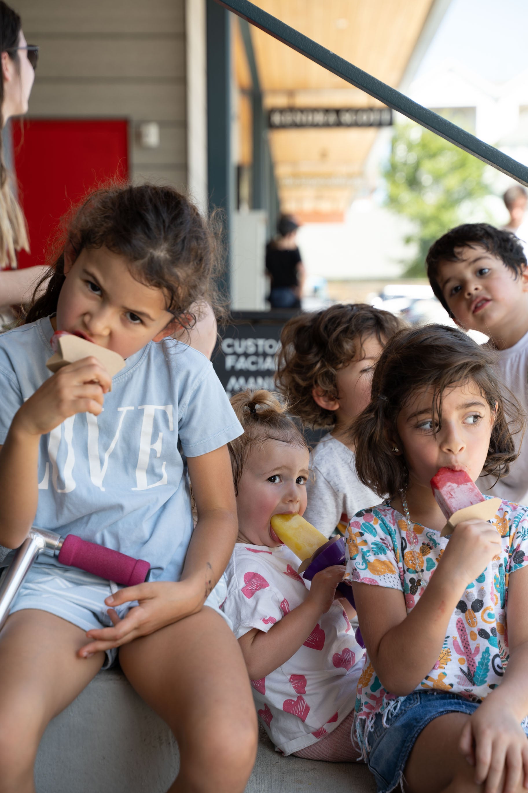 Three girls having a Fresh Fruit Ice Pop at a Farmers Market.